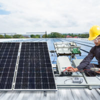 Engineer maintenance solar panel equipment on factory roof